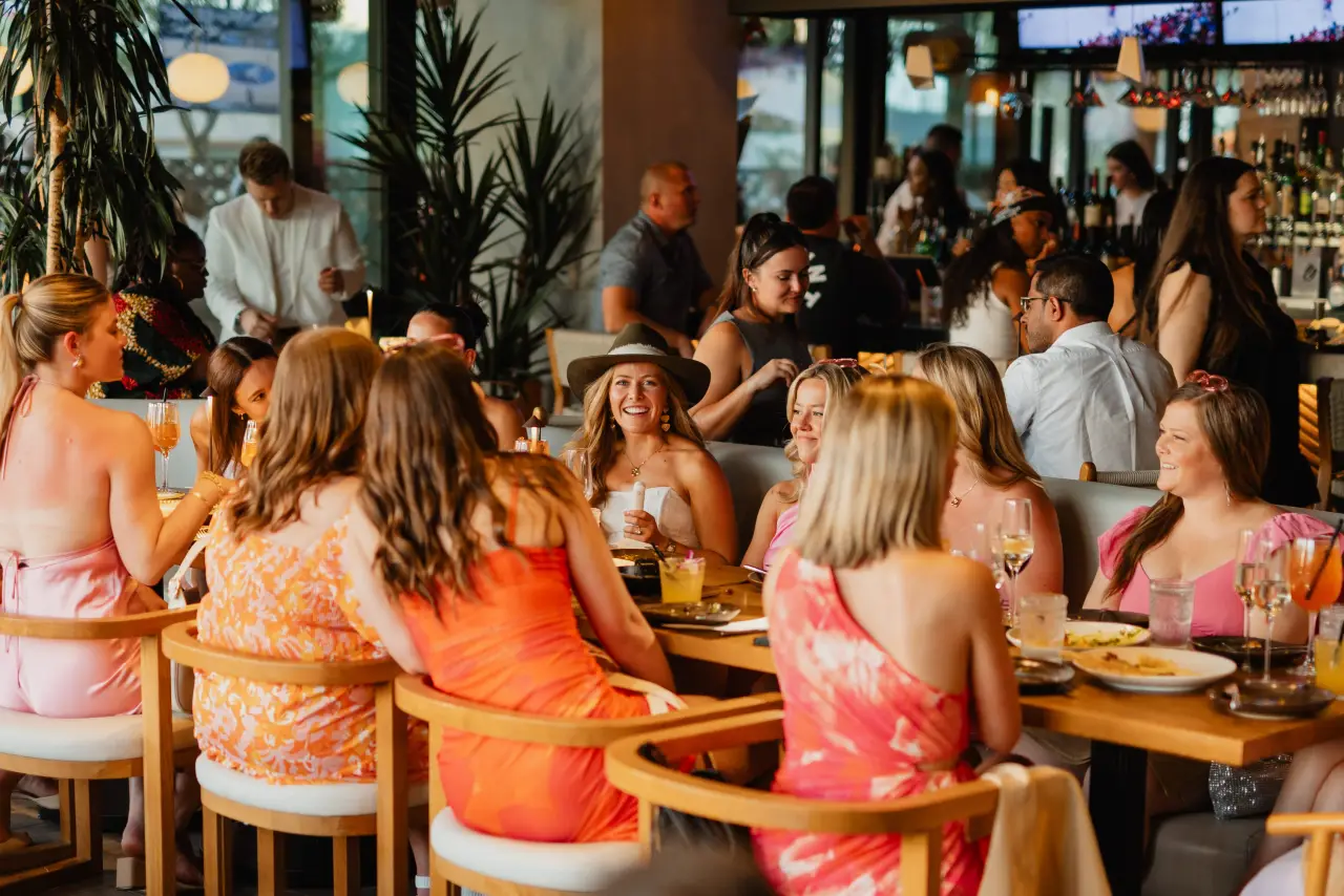 A big group of friends at a long table at CALA