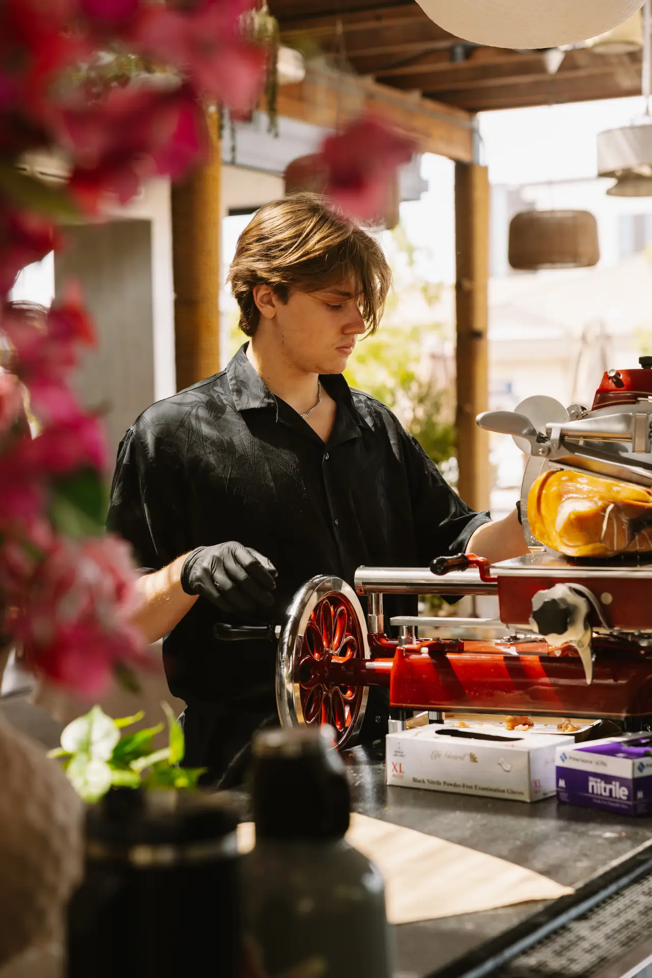 A chef carving prosciutto at the Cala Grand station