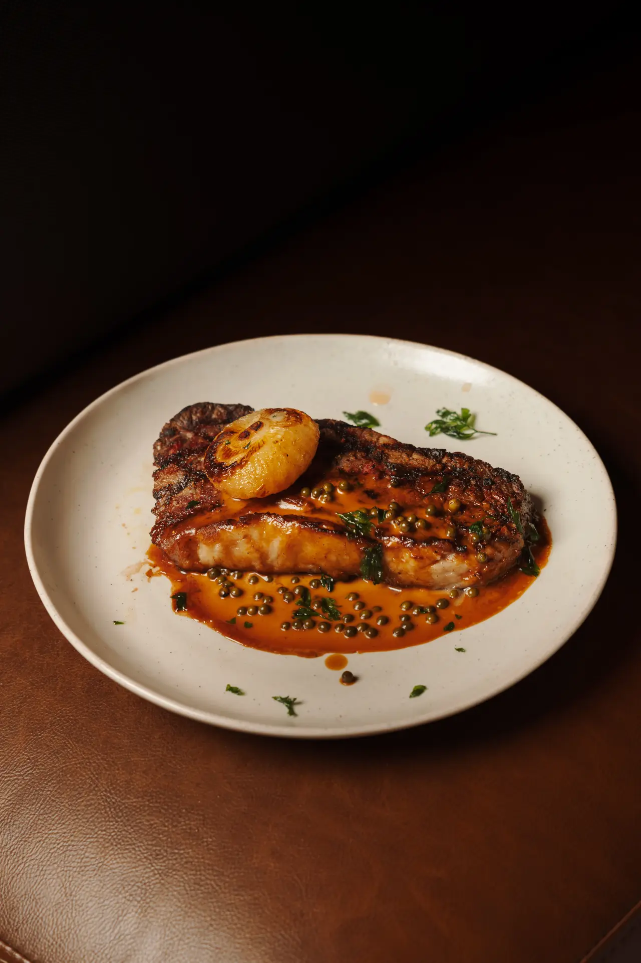 Steak with green peppercorn sauce and charred onion