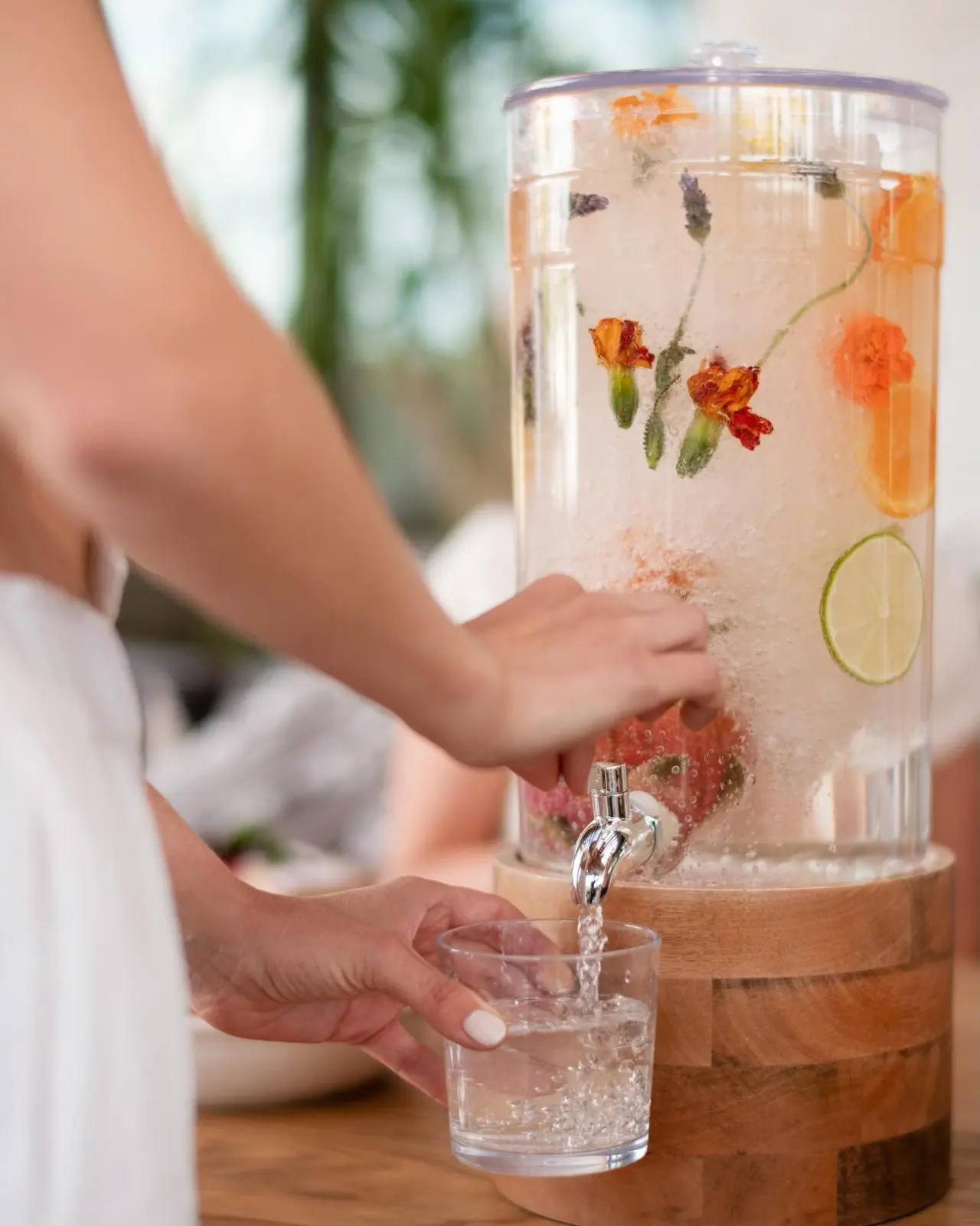A juice dispenser with flowers at breakfast