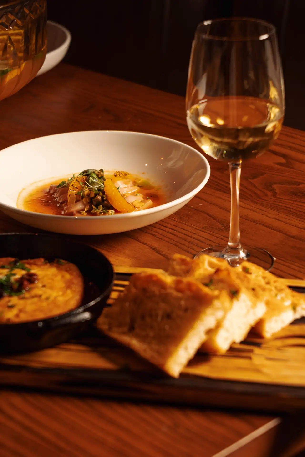 Focaccia, dips and wine on a table at CALA