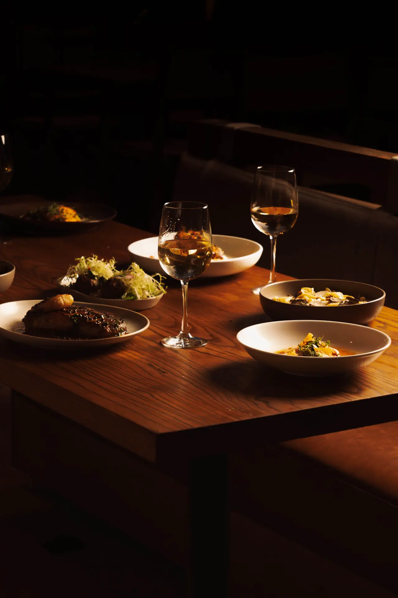 Shared plates and drinks at a table at night